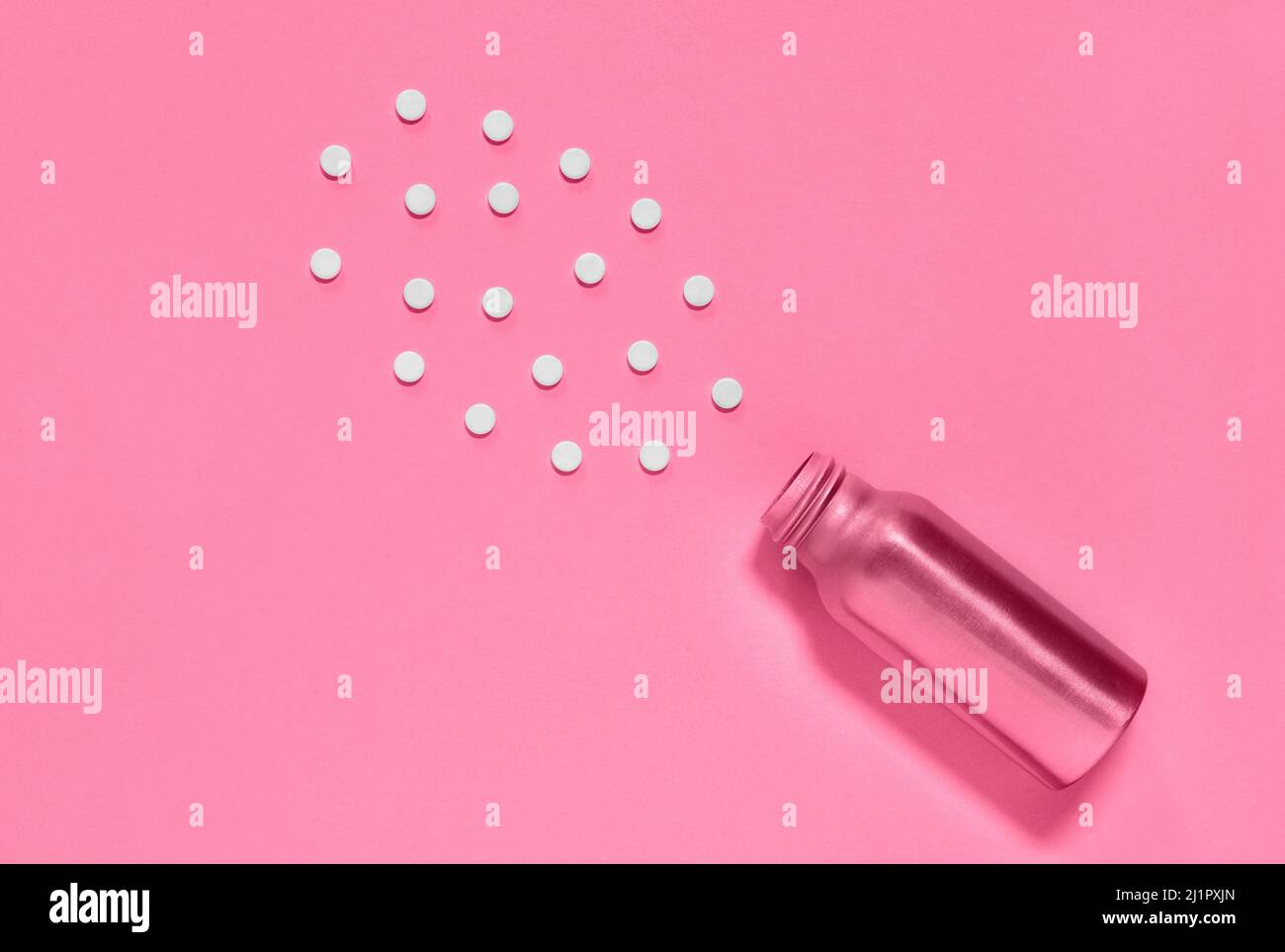 White pills and pink medicine bottle  on pink background , hearth care  and medicine Stock Photo
