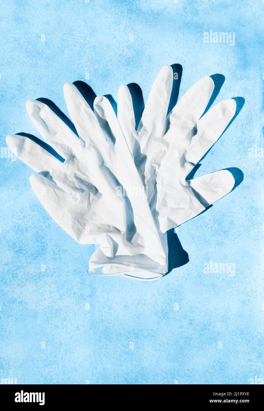 Pair of white surgical glove on blue background , health care and medicine Stock Photo