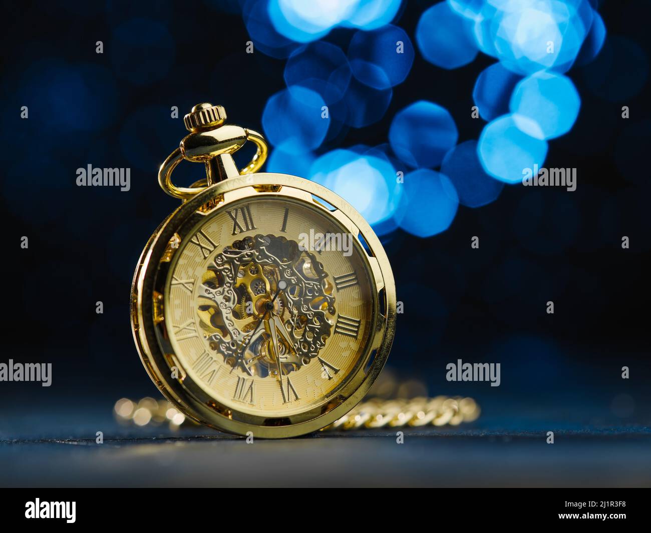 Vintage clock, alarm clock in gold color on a dark blue background with ...