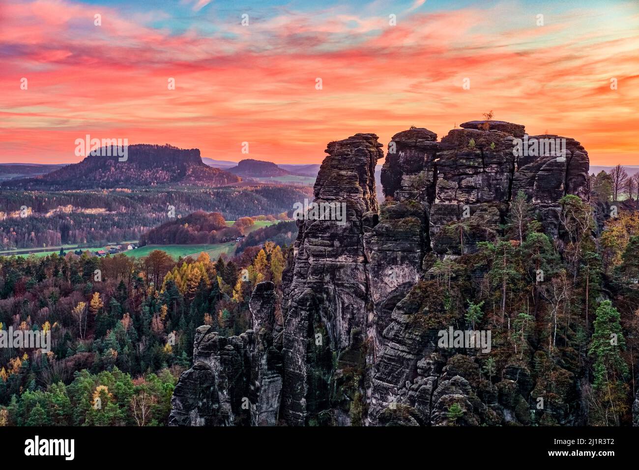 Landscape with rock formations, the summits Hintere Gans and Lilienstein in Rathen area of the Saxon Switzerland National Park at sunset in autumn. Stock Photo