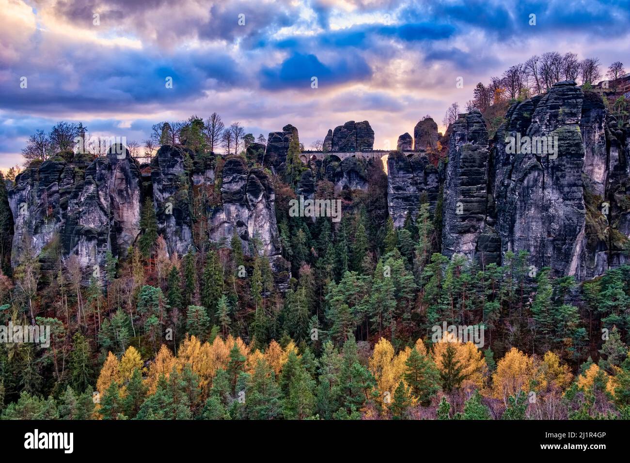 Landscape with the rock formations Felsenburg Neurathen and Bastei in Rathen area of the Saxon Switzerland National Park at sunset in autumn. Stock Photo
