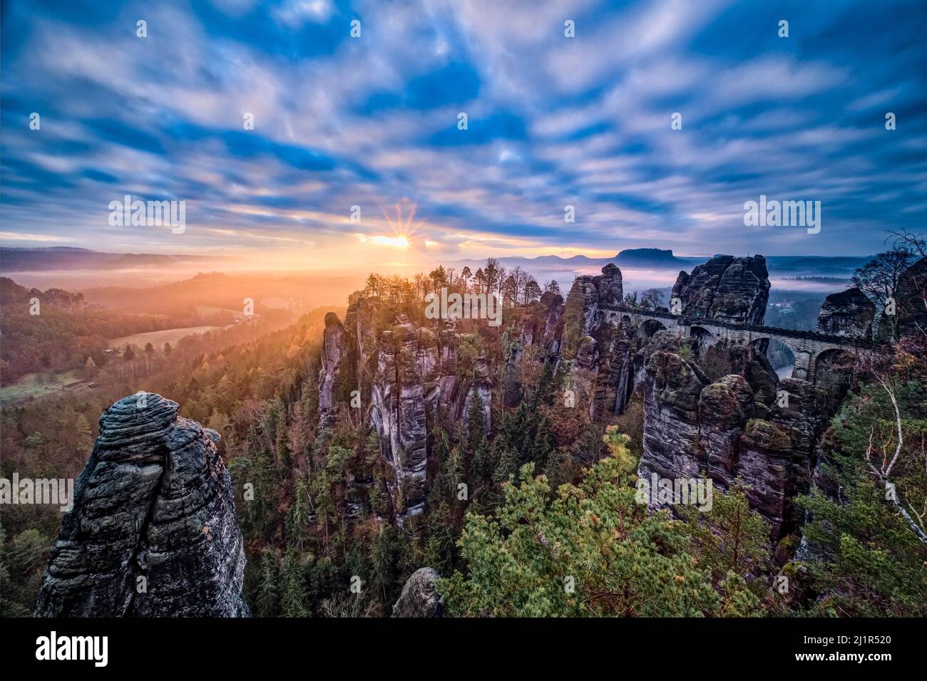 Landscape with the rock formations Felsenburg Neurathen and Bastei in Rathen area of the Saxon Switzerland National Park at sunrise in autumn. Stock Photo