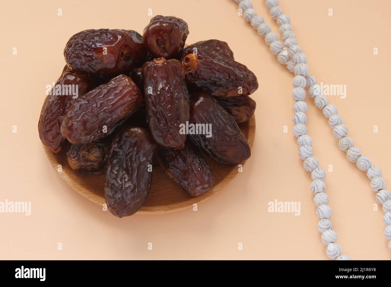 Fresh date fruits and white prayer beads, ramadhan concept idea. Sitting view. Vibrant color date fruit prepared for iftar. Stock Photo