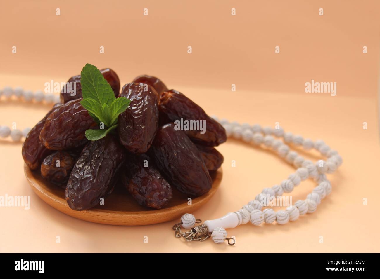 Fresh date fruits and white prayer beads, ramadhan concept idea. Sitting view. Vibrant color date fruit prepared for iftar. Stock Photo
