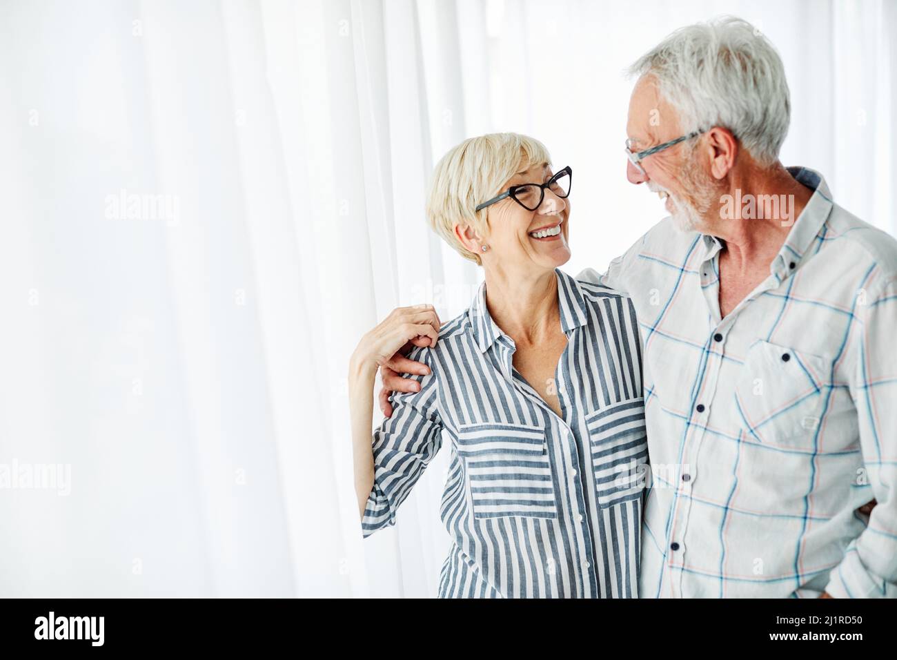 senior couple love together happy hug home family elderly man woman retirement smiling Stock Photo