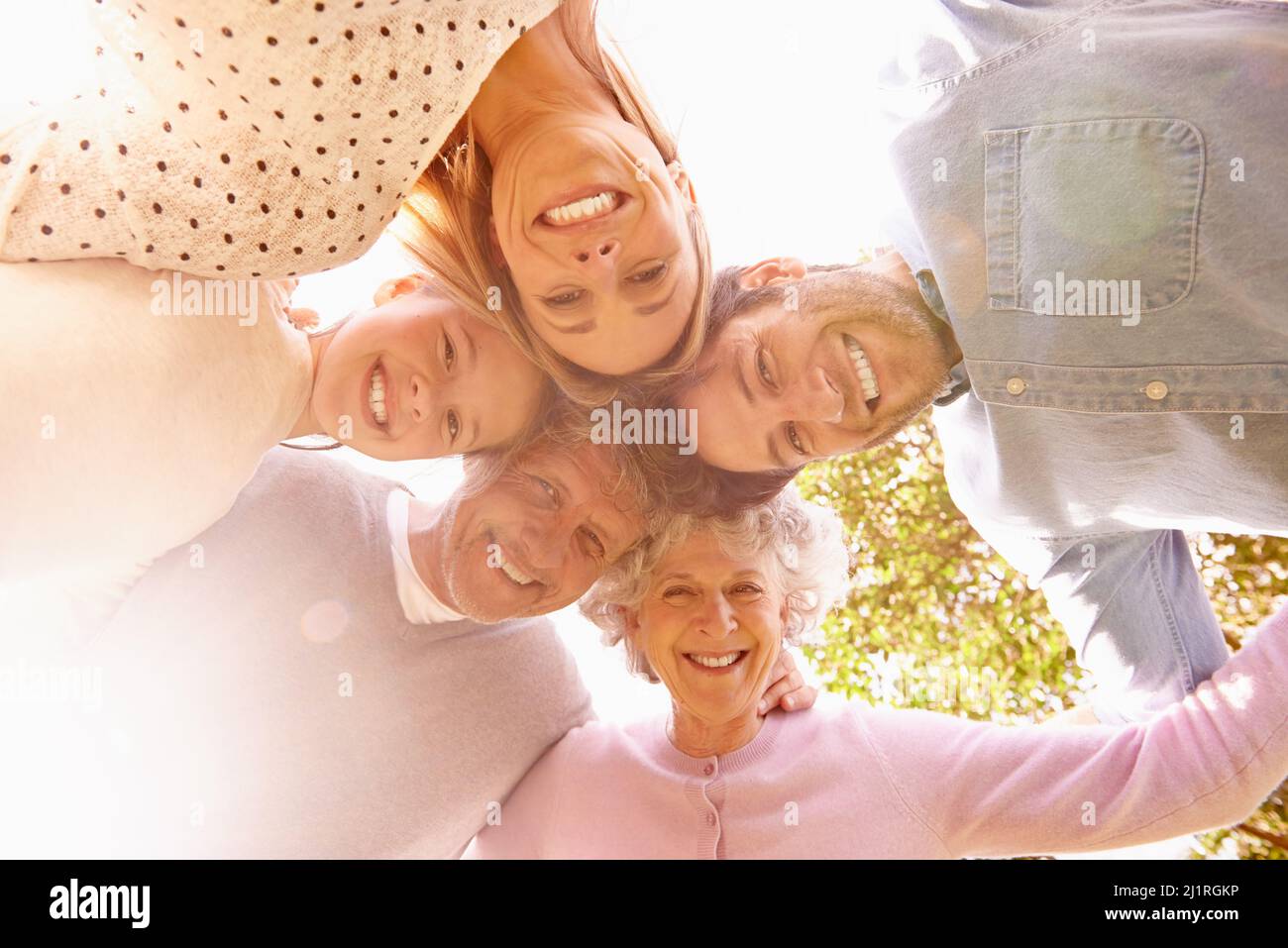 Our family sticks together. A low angle portrait of a happy family standing in a huddle. Stock Photo