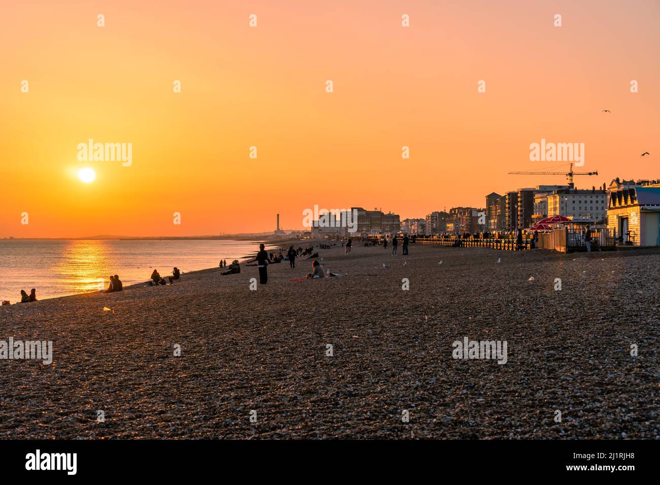 Hove, East Sussex, England. 27 March 2022. The beautiful sunset on Sunday evening along the seafront as Hove glows in the setting sun on an early spring evening on the first day of British summer time .©Sarah Mott / Alamy Live News Stock Photo