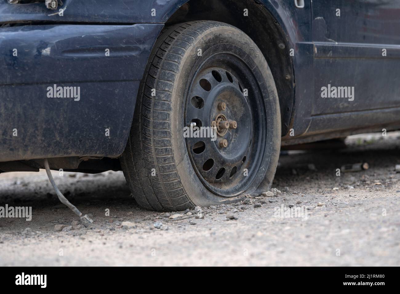 Old car with deflated wheel parked on street Stock Photo - Alamy