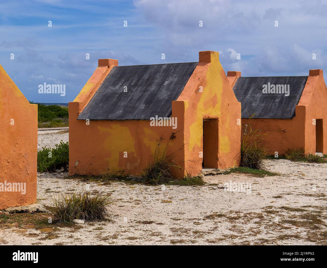 Multiple historic red slave hut sin Bonaire, Caribbean Stock Photo