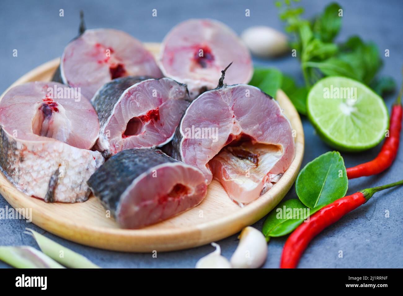 Snakehead fish for cooking food, striped snakehead fish chopped with ingredients lemon on wooden plate and table kitchen background, Fresh raw Snake h Stock Photo