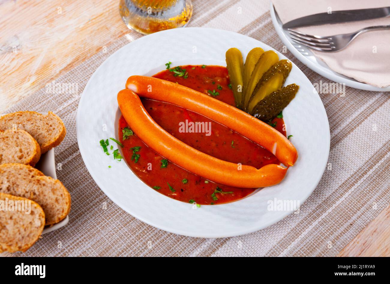Appetizing Vienna sausages with goulash sauce on served table Stock