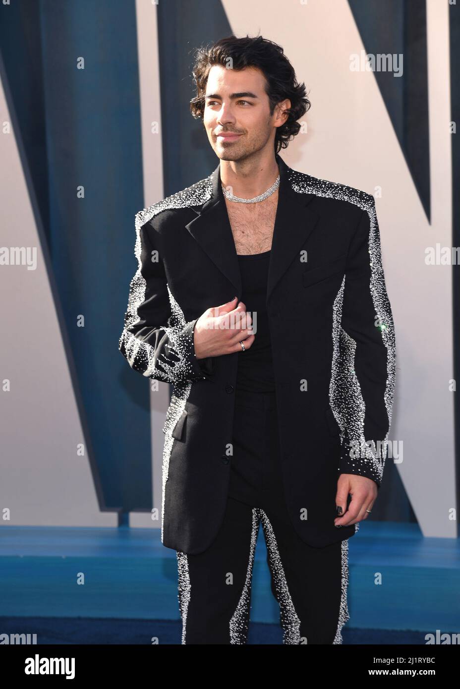 Joe Jonas walking on the red carpet at the 2022 Vanity Fair Oscar Party