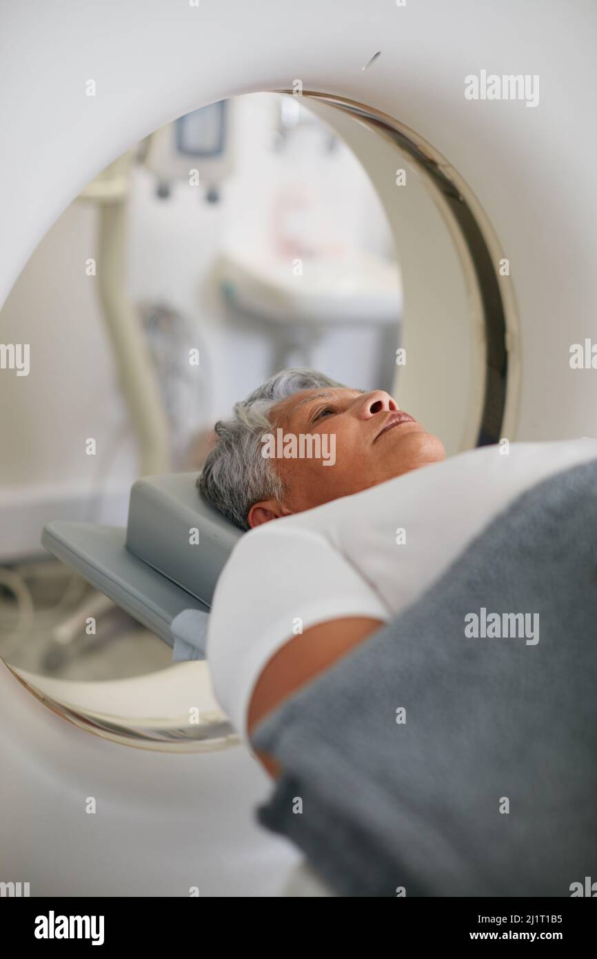 Scan in progress. Shot of a senior woman about to have an MRI scan. Stock Photo