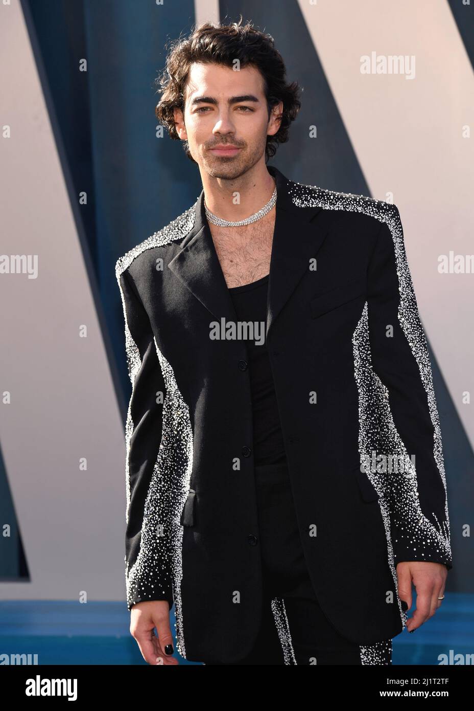 Joe Jonas walking on the red carpet at the 2022 Vanity Fair Oscar Party