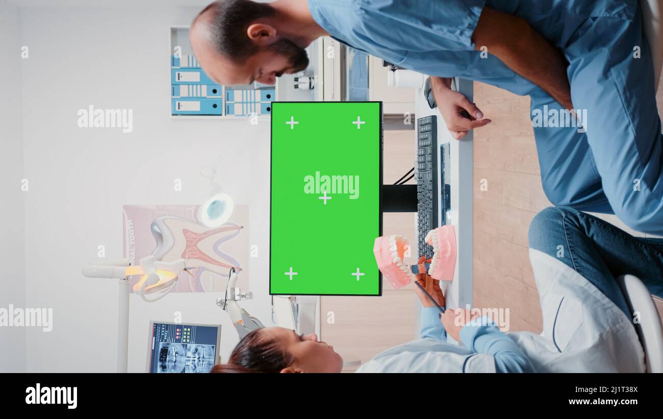 Vertical video: Team of specialists working with green screen on ...