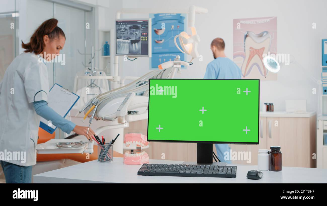 Horizontal green screen on computer in dental while dentist and
