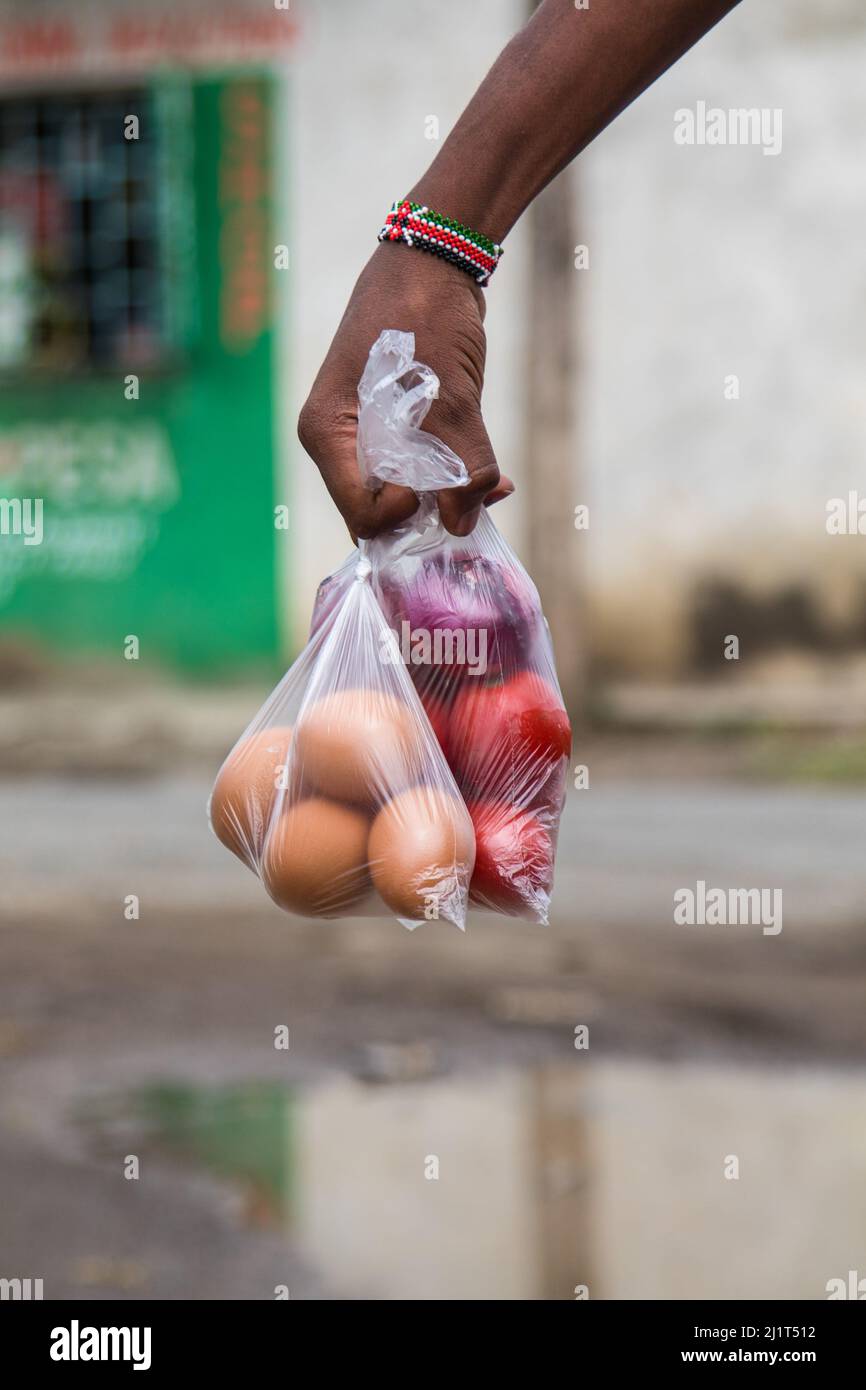 A young man is seen carrying vegetables and eggs packed in banned