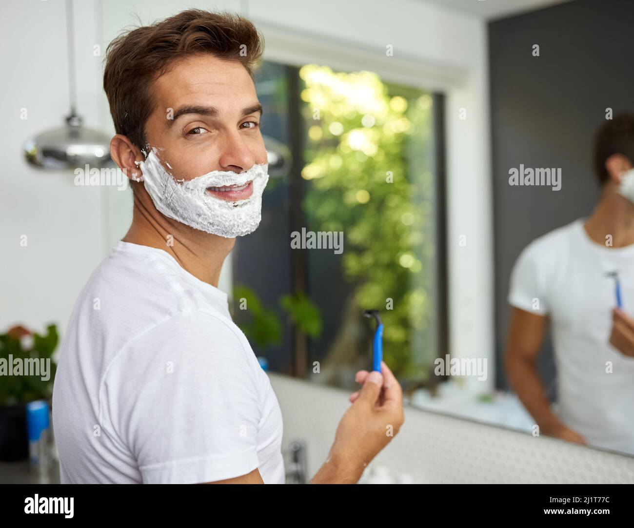 The cream before its all gone. Cropped shot of a handsome man about to shave his beard in the bathroom at home. Stock Photo