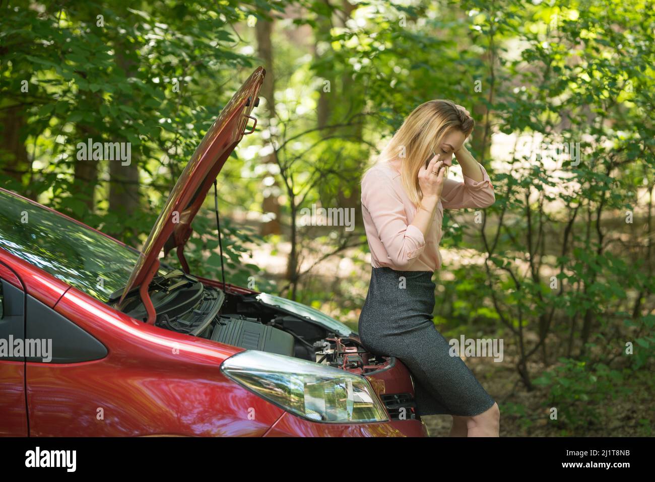 Girl with a broken car, with an open hood Stock Photo - Alamy