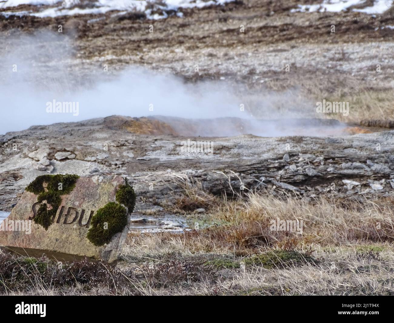 A view of the hot steam coming out from the ground in the great Geysir on a sunny winter day in South Iceland Stock Photo