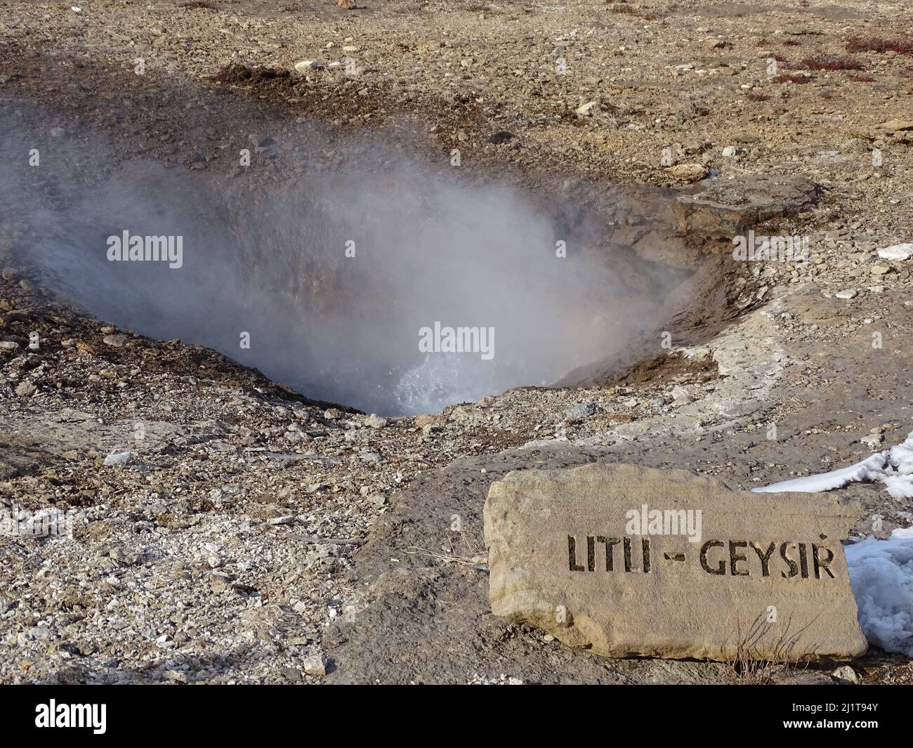 A view of the hot steam coming out from the ground in the great Geysir on a sunny winter day in South Iceland Stock Photo