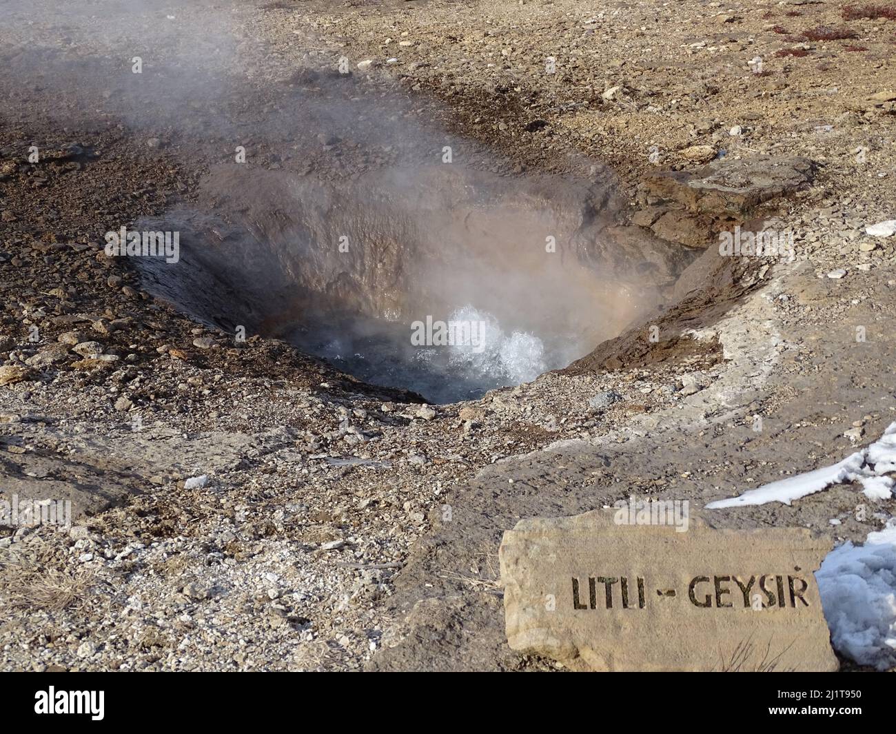 A view of the hot steam coming out from the ground in the great Geysir on a sunny winter day in South Iceland Stock Photo