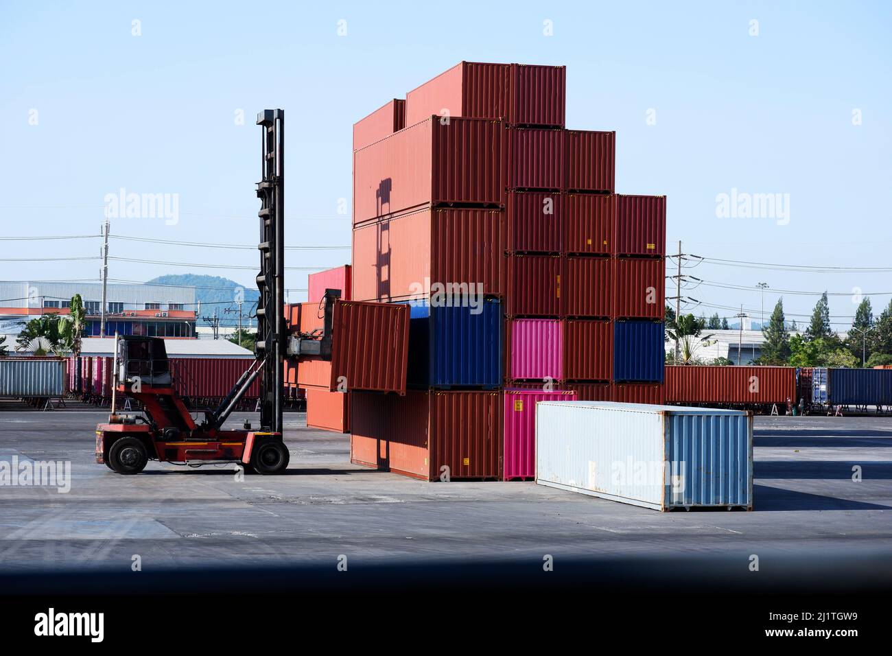 Industrial logistics transport forklift truck transport container box loading stacker at port to truck for shipping export and import trade goods at p Stock Photo