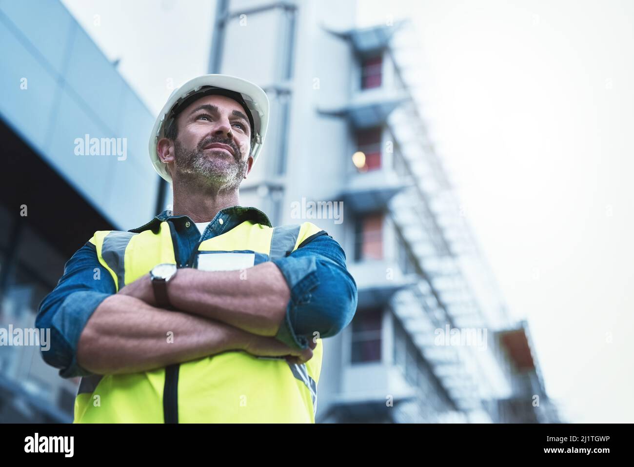 Youll always get a solid foundation with him. Shot of a engineer standing in front of a building. Stock Photo