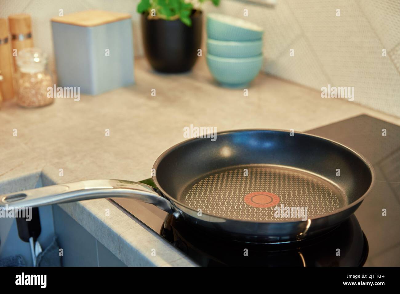 Steel frying pan in the kitchen on electric induction hob, Modern
