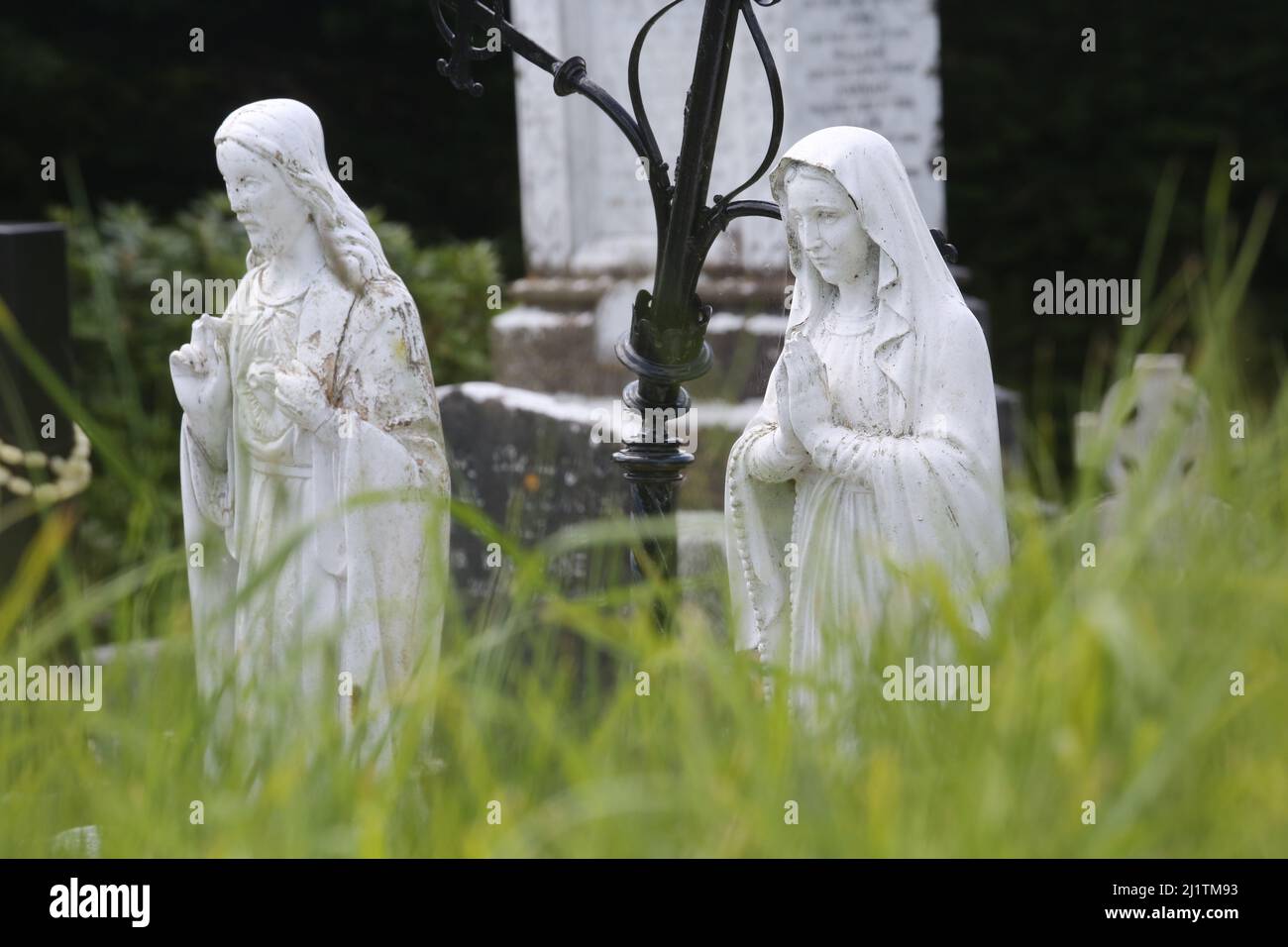 Religious statues in a cemetery in Ireland among other Catholic symbols
