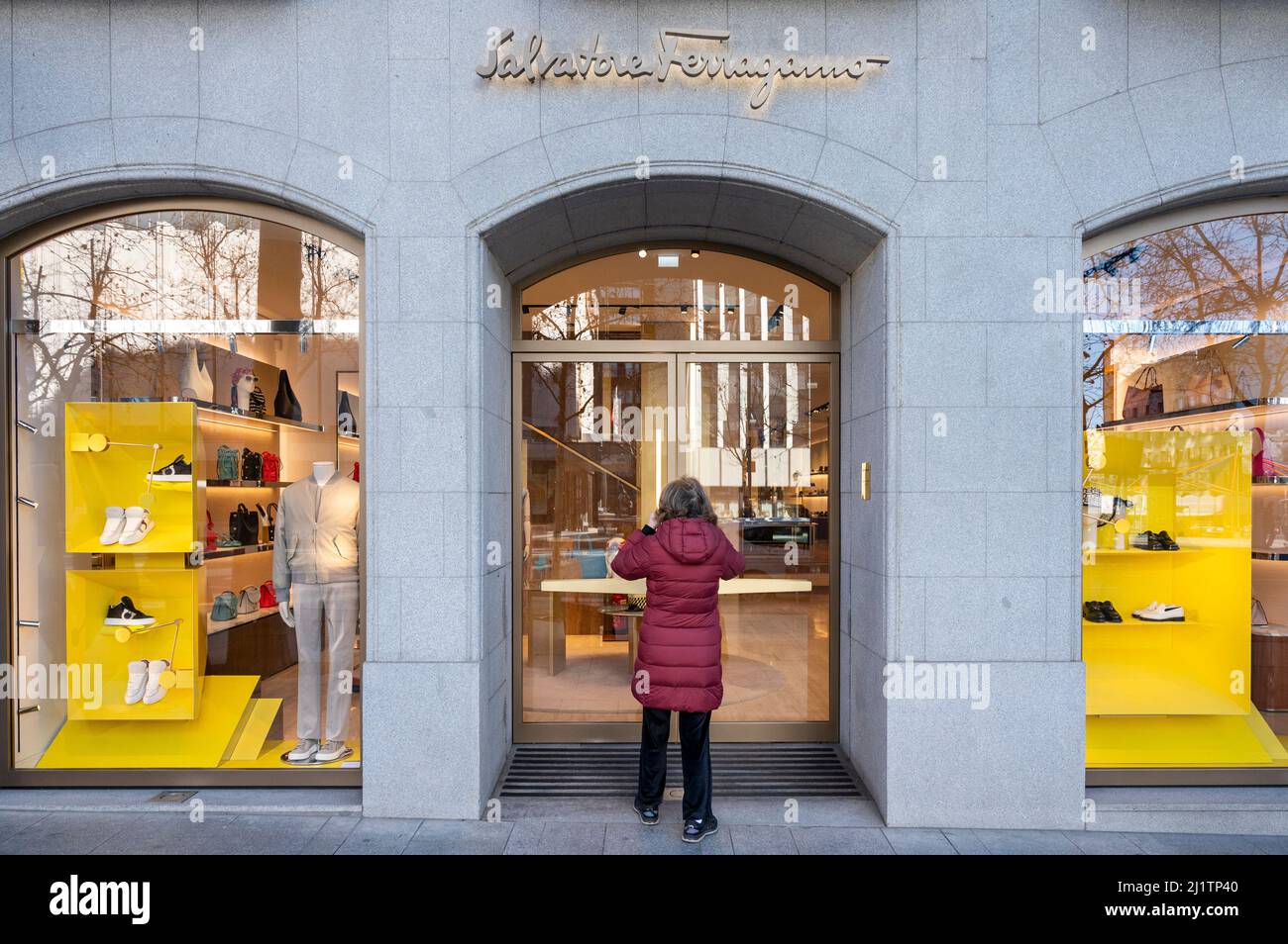 A shopper walks in into the Italian luxury shoe brand Salvatore Ferragamo store in Spain. Stock Photo