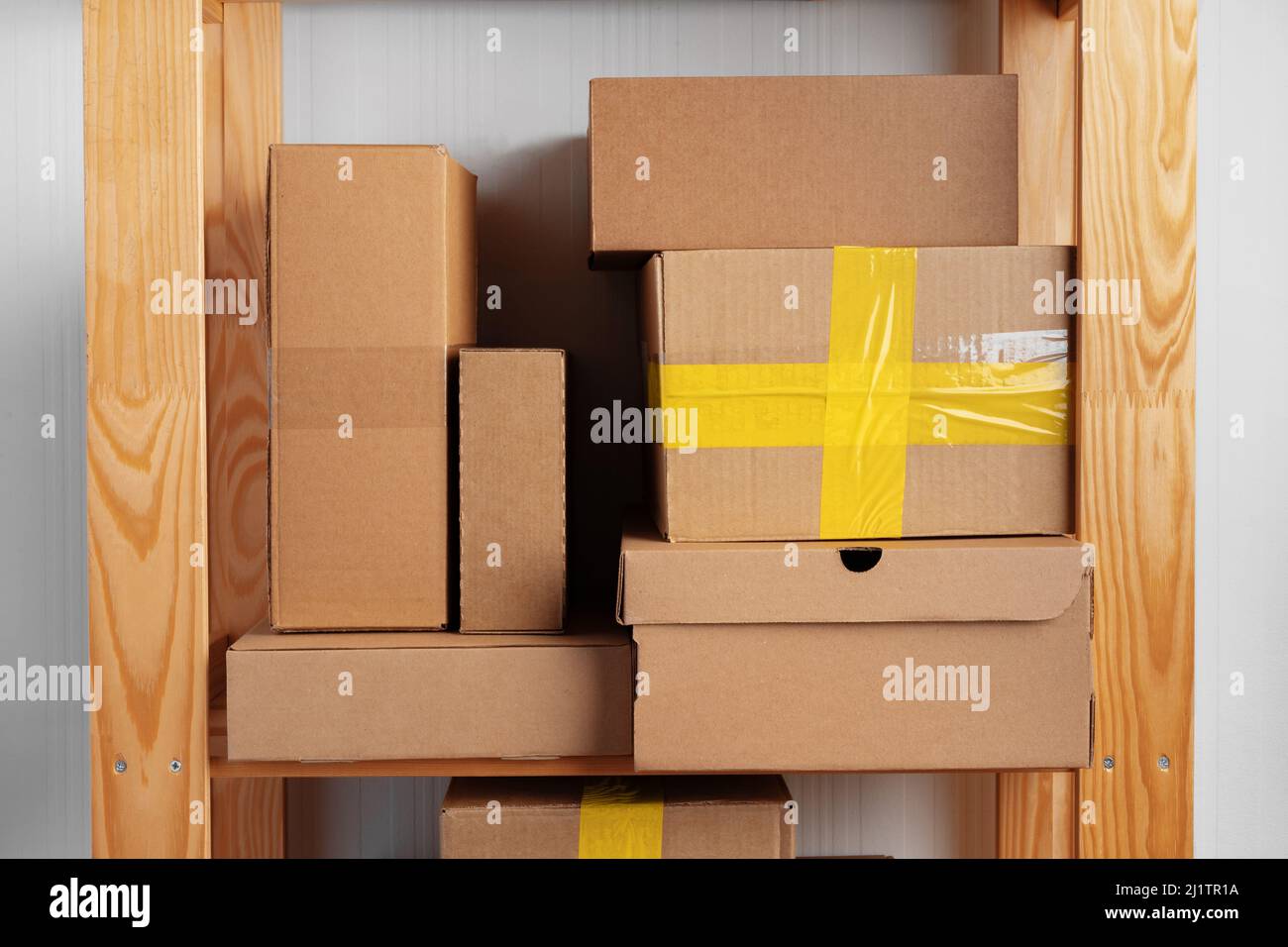 Stack of cardboard package boxes on wooden rack Stock Photo