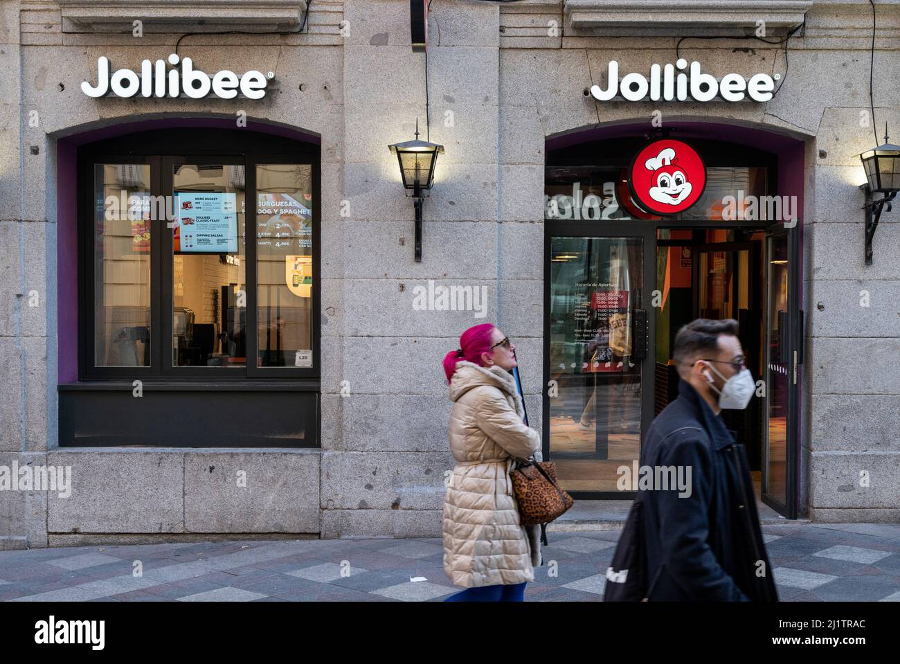 Madrid, Spain. 24th Mar, 2022. Pedestrians walk past the Filipino multinational chain of fast food Jollibee restaurant in Spain. (Photo by Xavi Lopez/SOPA Images/Sipa USA) Credit: Sipa USA/Alamy Live News Stock Photo