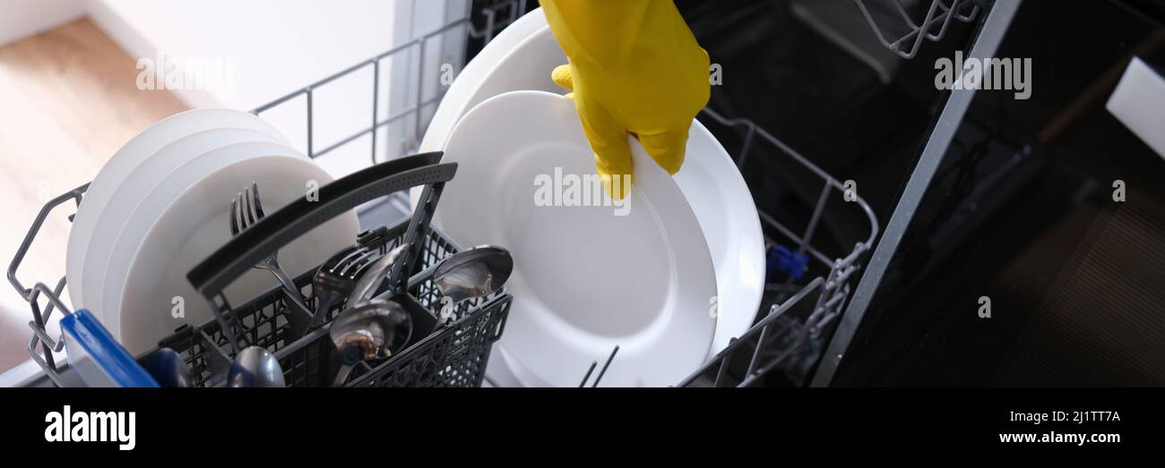 Loading dishes into the dishwasher, plate, fork, spoon Stock Photo Alamy