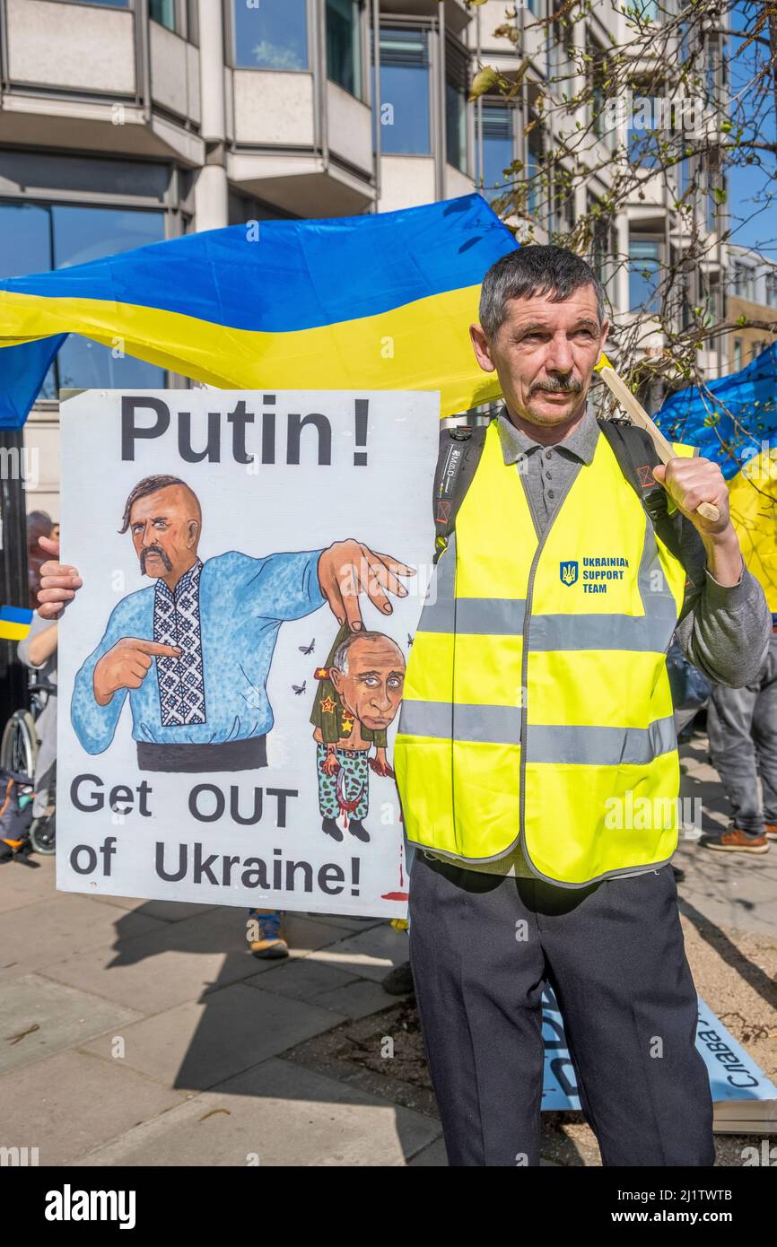 Protesters with signs at the London Stands With Ukraine demonstration, London, in protest of President Vladimir Putin's Russian invasion of Ukraine. Stock Photo