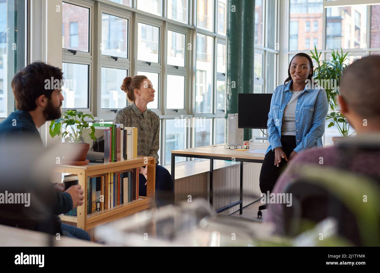 Smiling African businesswoman talking with colleagues during an office meeting Stock Photo