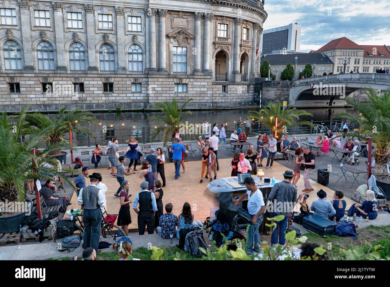 Berlin, Germany - August 8, 2021: People dancing at Strandbar Mitte open air beach bar dance floor in the city center with Bode Museum at river Spree Stock Photo