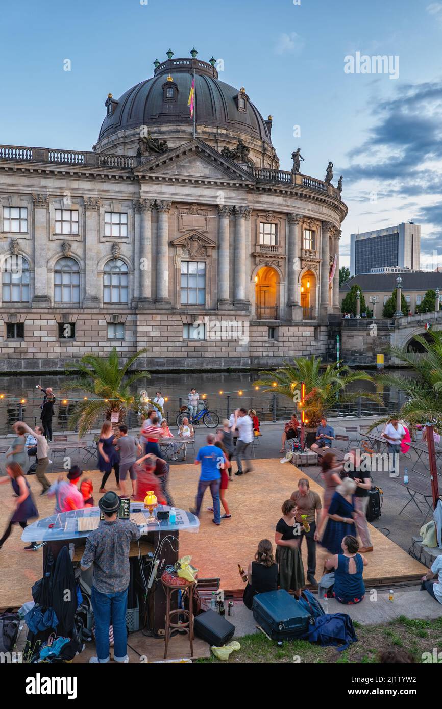 Berlin, Germany - August 8, 2021: People dancing at Strandbar Mitte open air beach bar dance floor in the city center with Bode Museum at river Spree Stock Photo