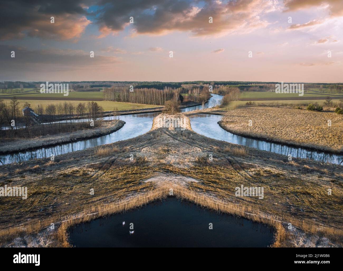 Sunset over a small river in the spring evening. Stock Photo