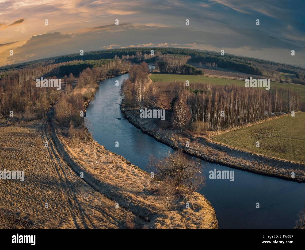 Sunset over a small river in the spring evening. Stock Photo