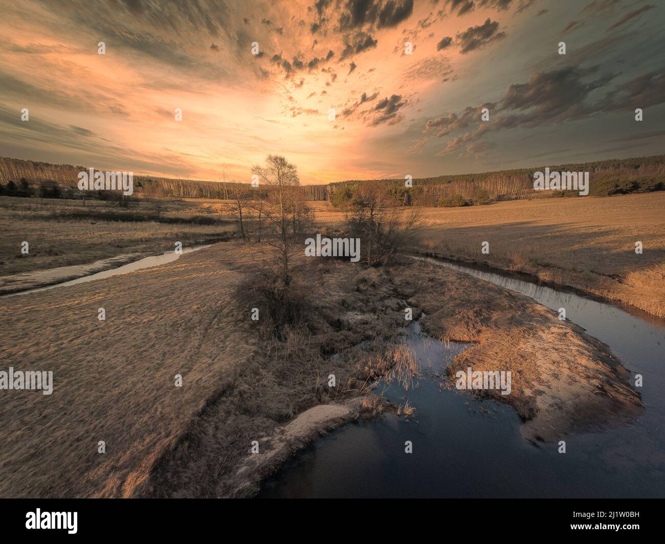 Sunset over a small river in the spring evening. Stock Photo