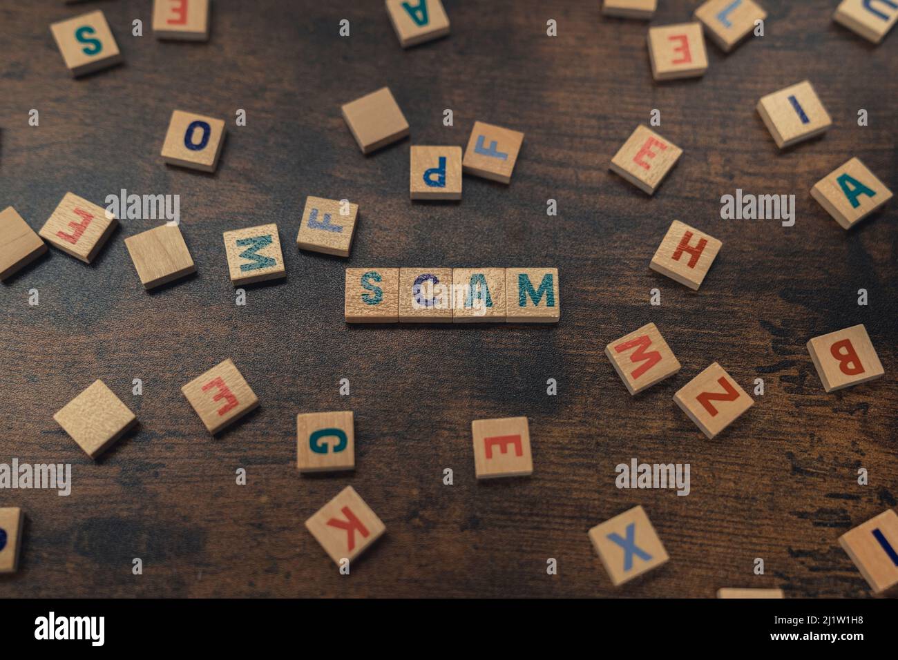 SCAM a word put together with aligned wooden blocks with letters