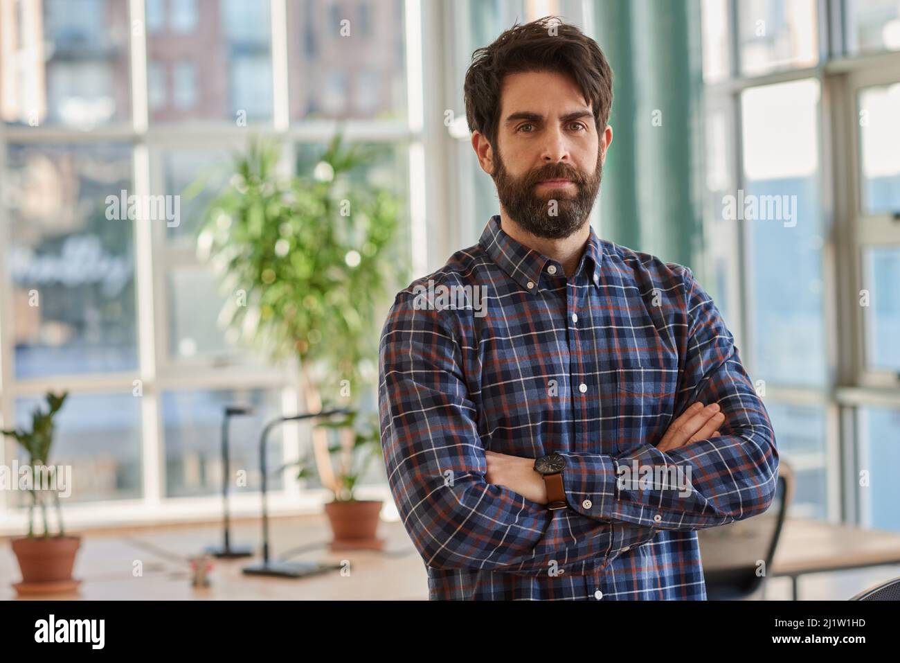 Confident businessman standing with his arms crossed in an office Stock ...