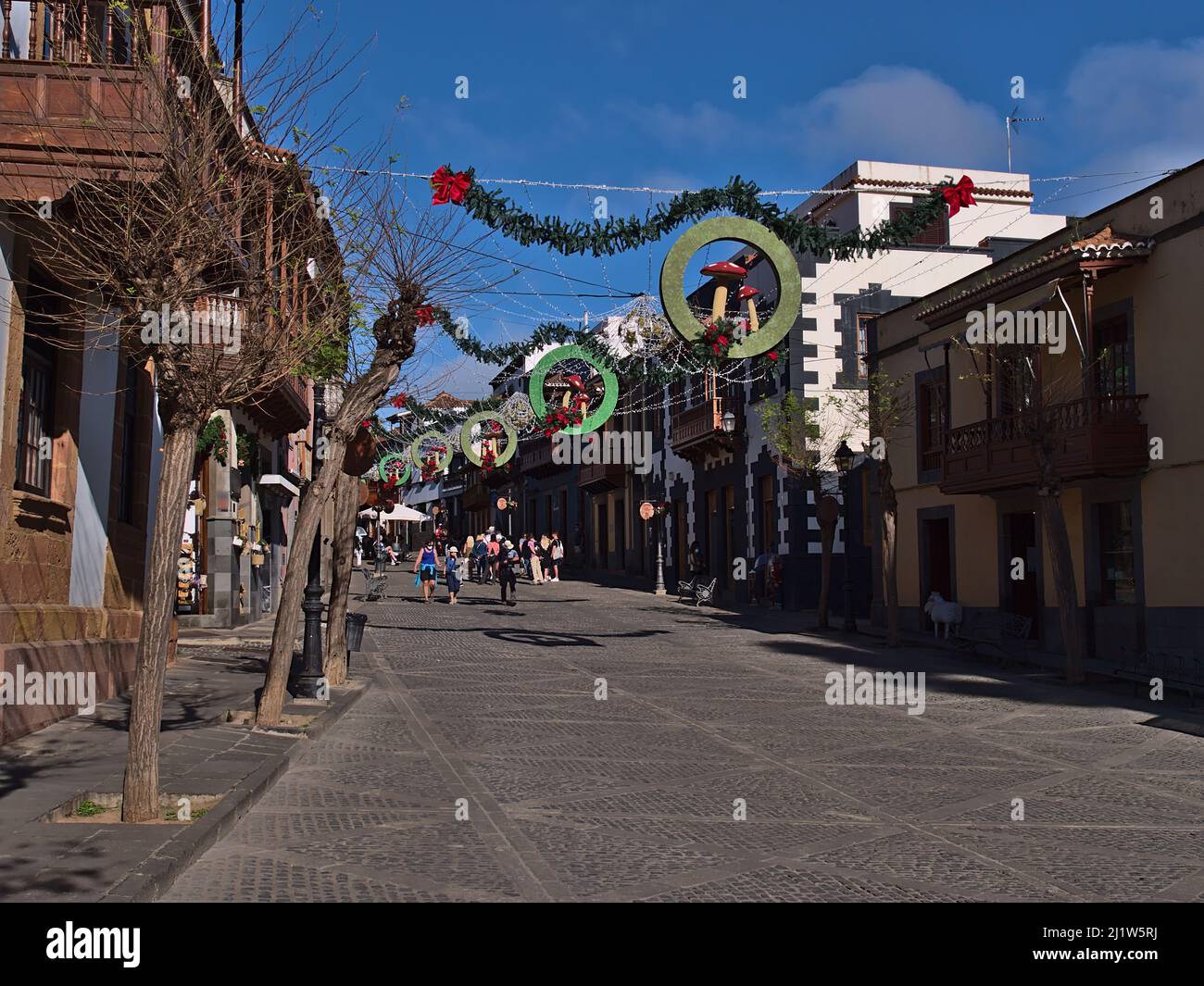 Tourists walking through pedestrianz zone in the historic center of old town Teror in Gran Canaria, Canary Islands, Spain in winter season with shops. Stock Photo