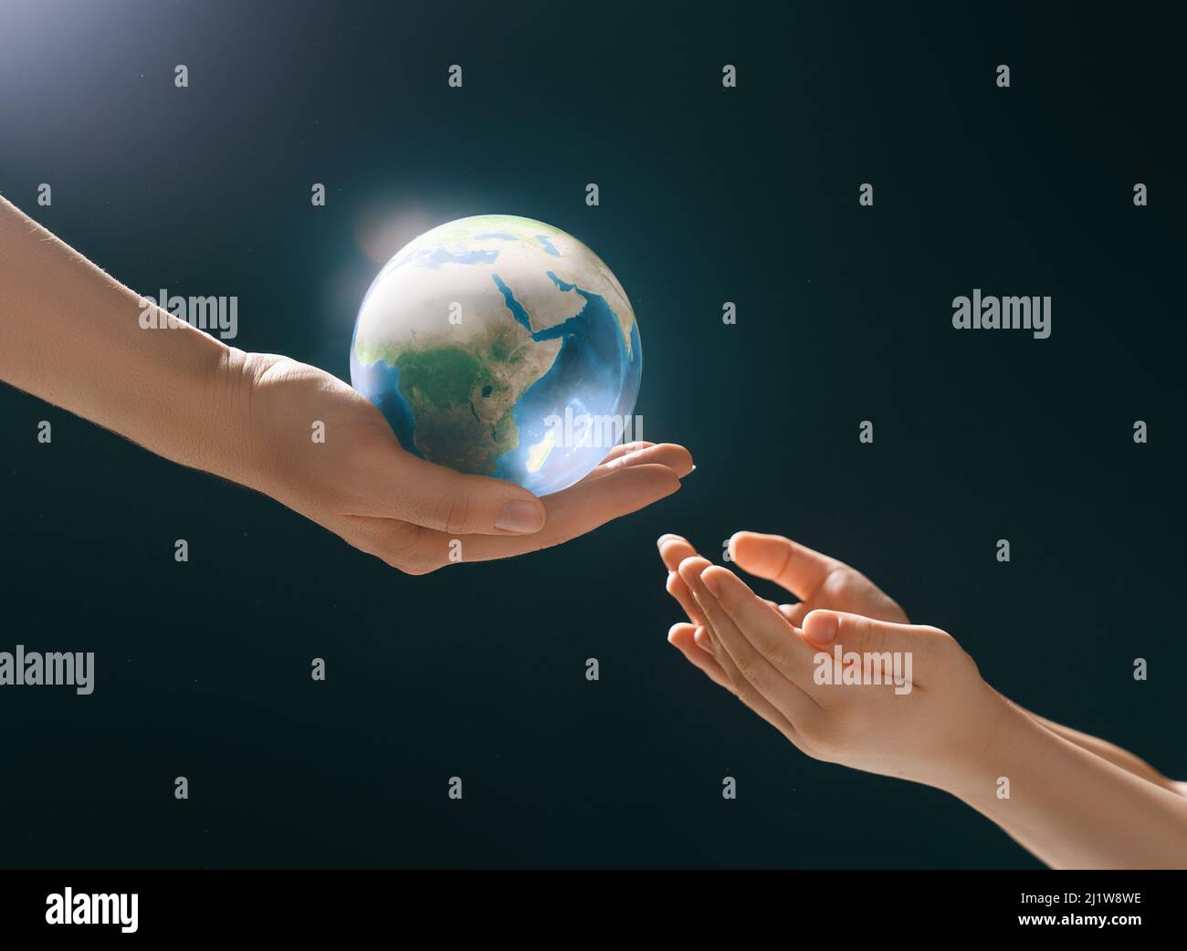 Child and adult holding planet in hands on dark background. Earth day ...