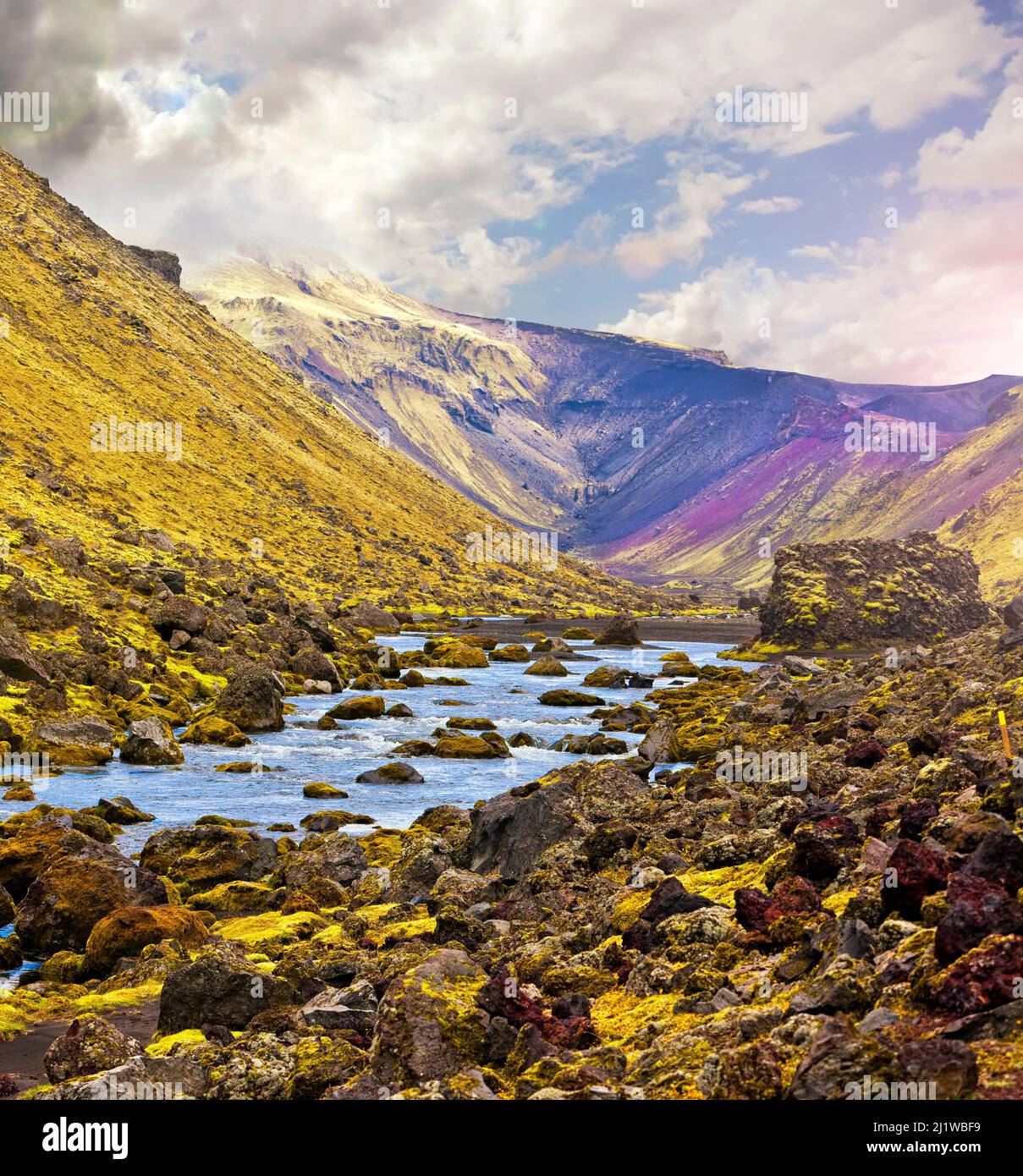 River along a Valley in Landmannalaugar among colorful green and magenta mountainous landscapes, Iceland Stock Photo