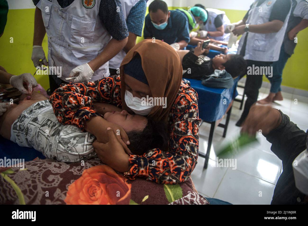 A boy seen crying during a mass circumcision process at a Muslim school in  Medan, North Sumatra province, Indonesia on March 27, 2022. A total of 50  boys undergo circumcision as a