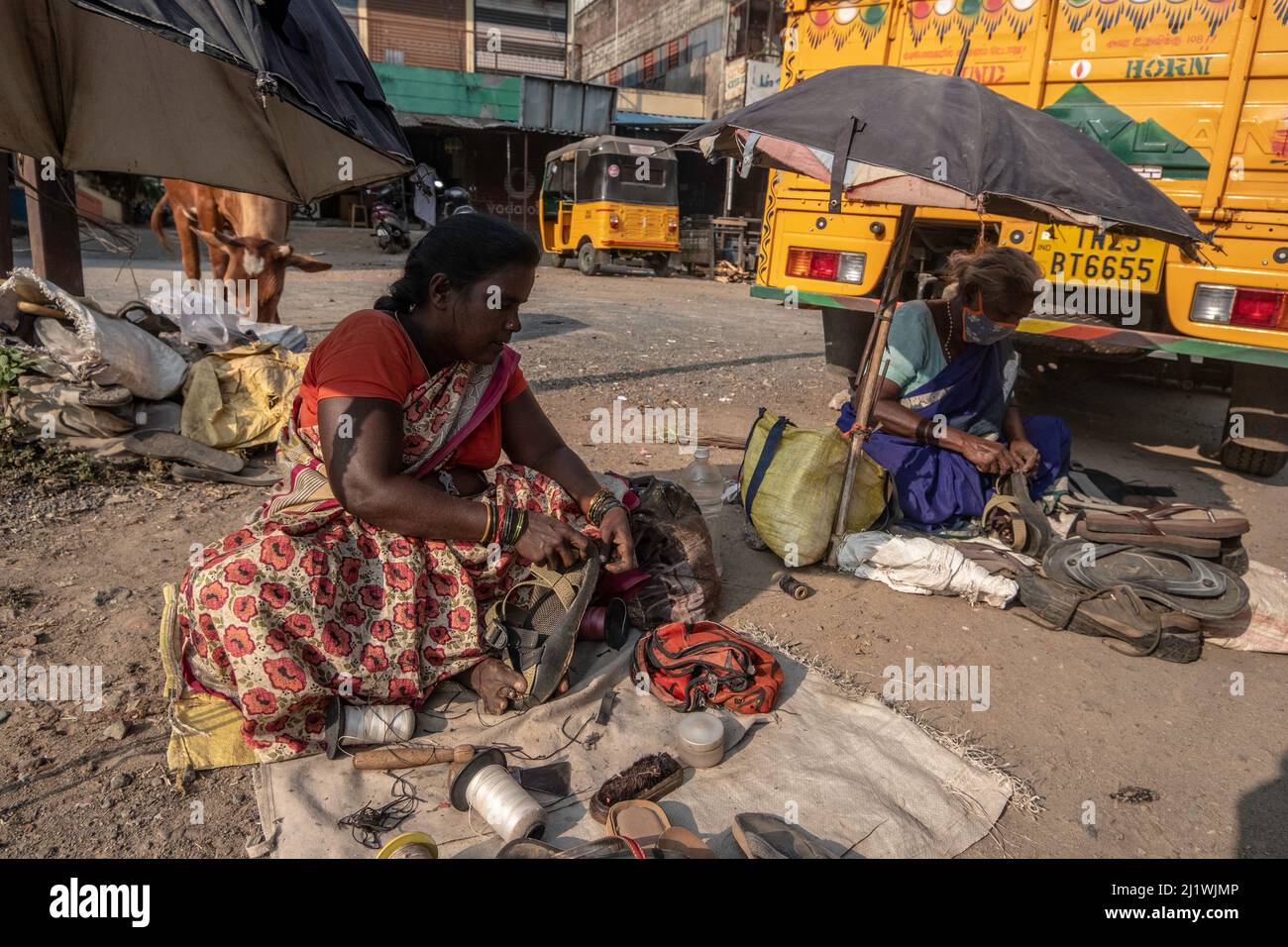 Seamstress fixes and sells used clothes at the Market at Tiruvannamalai, Tamil Nadu, India Stock Photo