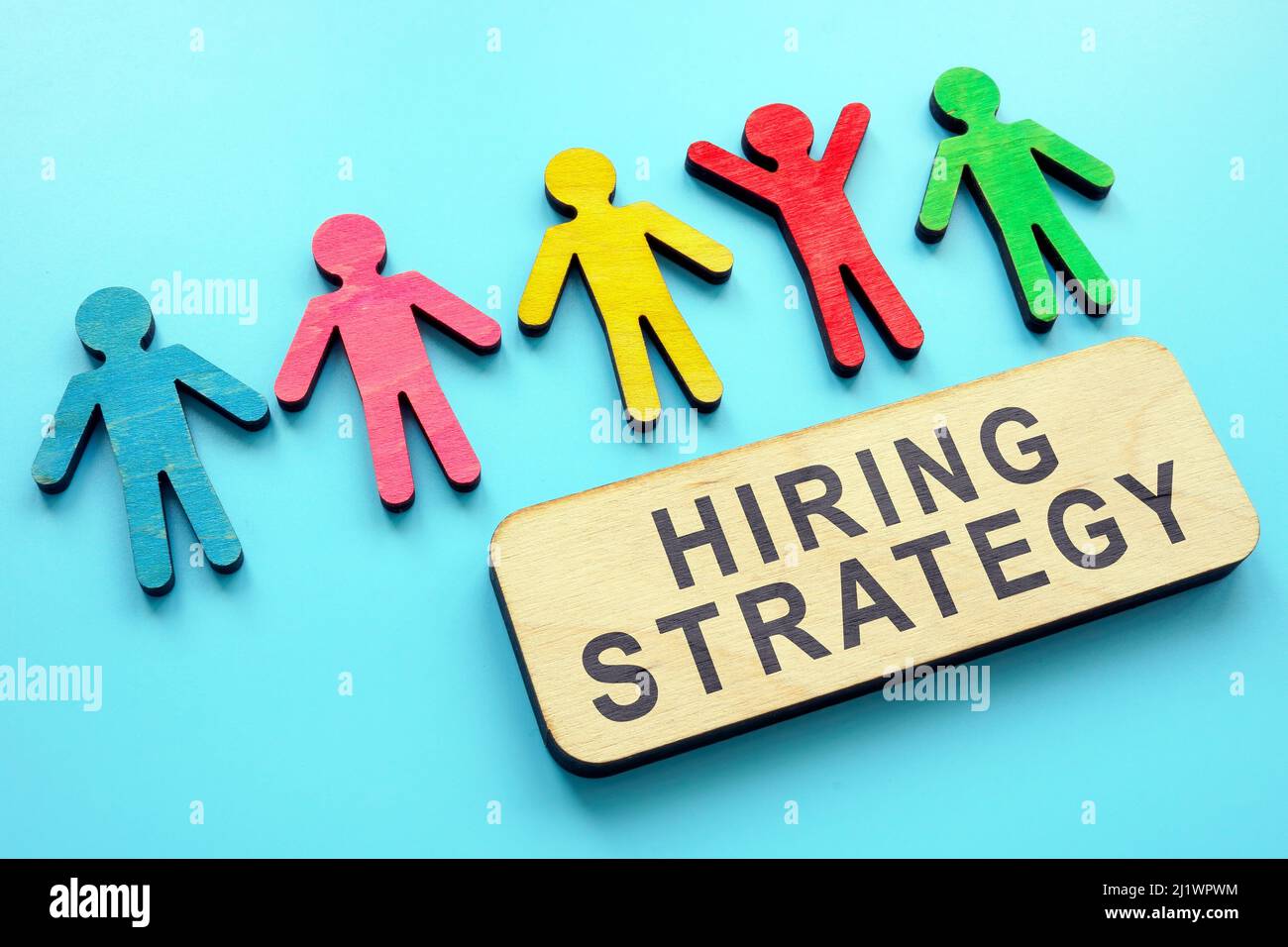 Hiring strategy sign on the board and figurines. Stock Photo