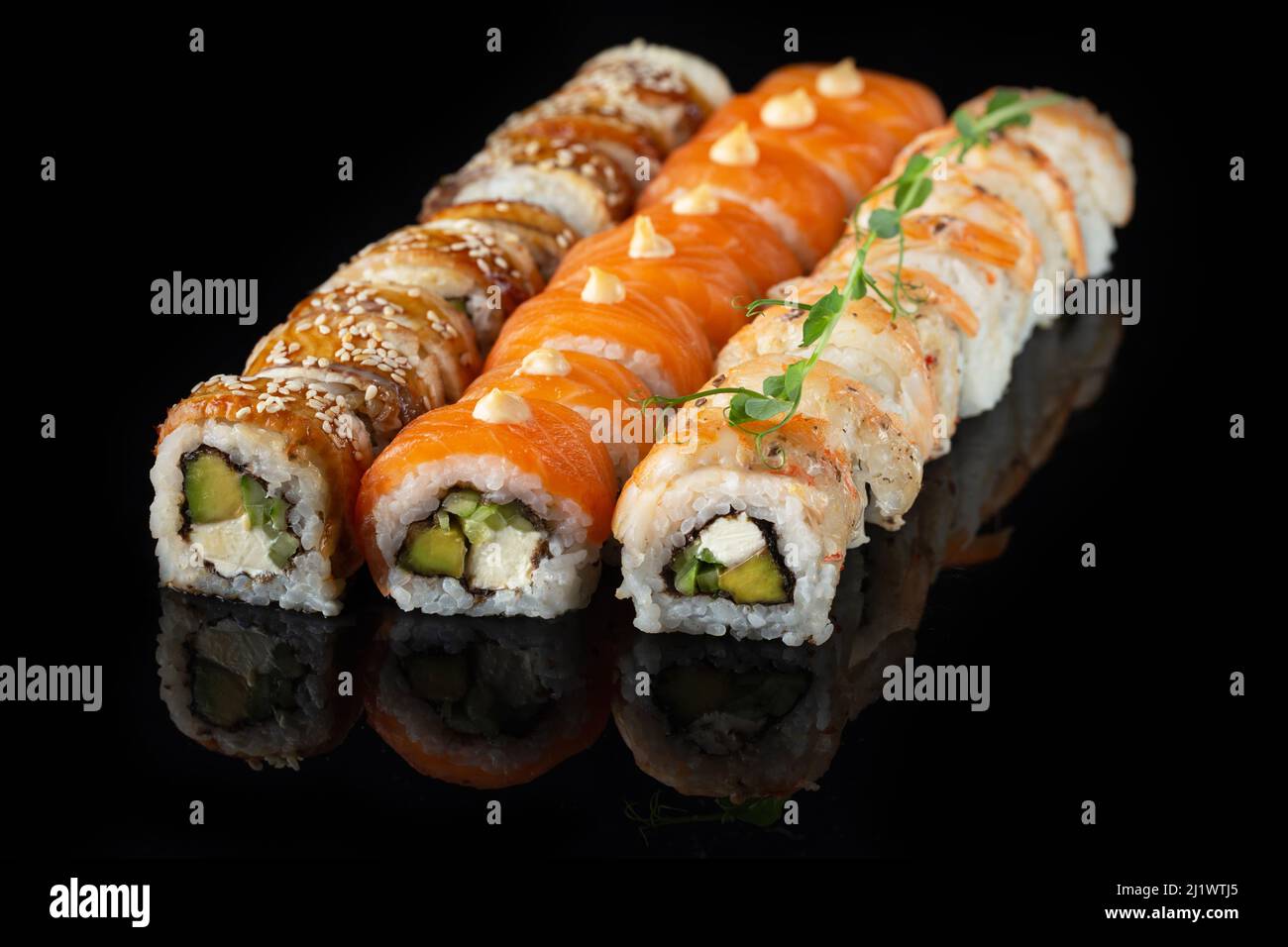 Traditional delicious fresh sushi roll set on a black background with ...